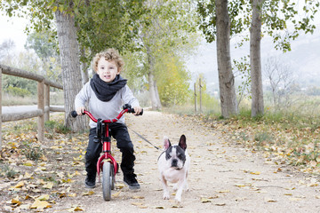 Naklejka na ściany i meble child riding bike with dog