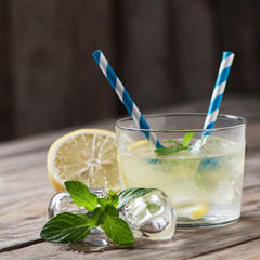 Lemonade with fresh lemon on wooden backgroun