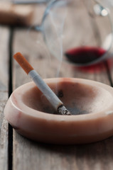 Cigarette and wine on the wooden table