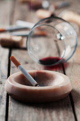 Cigarette and wine on the wooden table