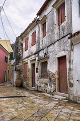 Fototapeta na wymiar Street and buildings in Paxoi island, Greece, on an overcast day