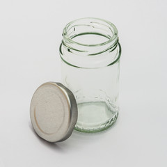 Glass bottle with silver lid isolated on white background