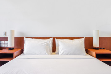 Bed, pillows and lamp in the hotel room