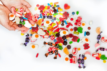 Woman hands holding colorful candies isolated on white