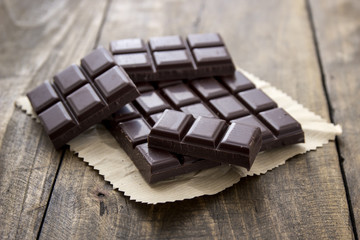 Broken chocolate bar  on wooden table.