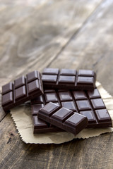 Broken chocolate bar  on wooden table.