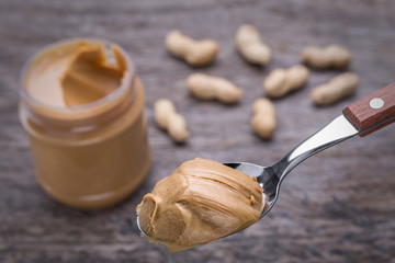 Peanut cream in spoon. Against the background of nuts
