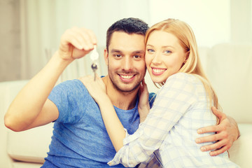 smiling couple holding keys at home