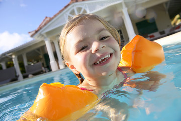 Cheerful 4-year-old girl playing in pool