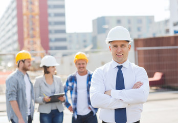 group of smiling builders in hardhats outdoors