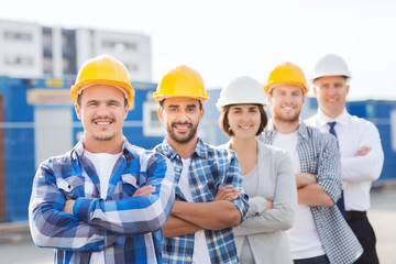 group of smiling builders in hardhats outdoors