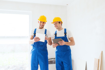 builders with tablet pc and equipment indoors