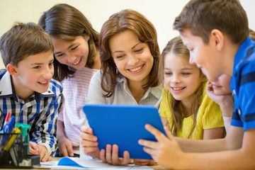 group of kids with teacher and tablet pc at school