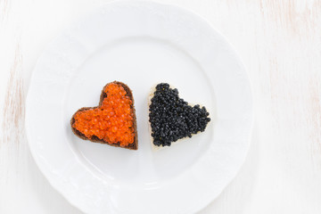 festive appetizer - toasts in heart shape on plate, top view