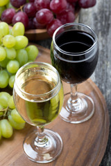 glass of white and red wine, fresh grapes on a wooden board