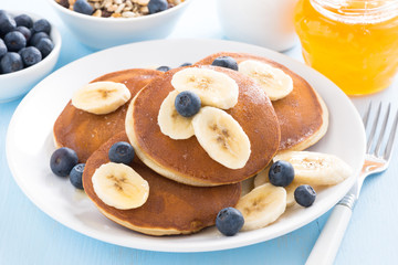 pancakes with banana, honey and blueberry on a plate