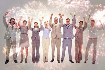 Composite image of happy business team raising their arms