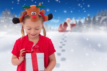 Composite image of cute little girl wearing rudolph headband