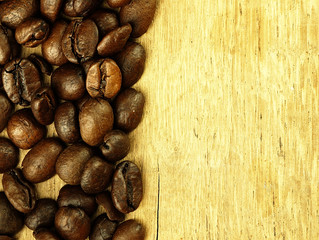 Coffee beans close-up on wooden, oak table.