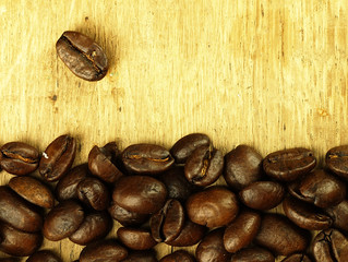 Coffee beans close-up on wooden, oak table.