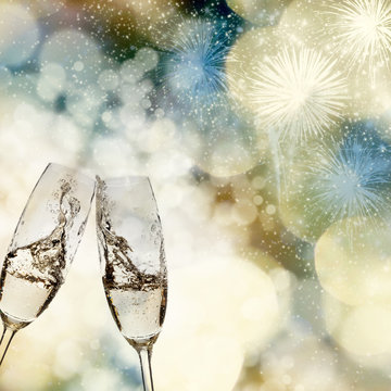 New Year's - toasting with champagne glasses against fireworks a