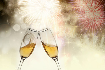 New Year's - toasting with champagne glasses against fireworks a