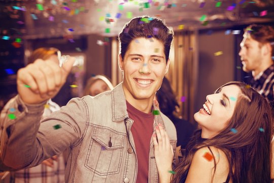 Composite image of stylish couple smiling and dancing together