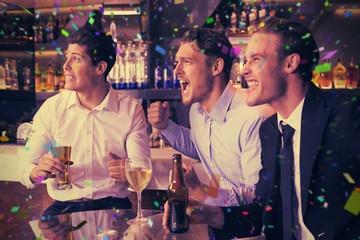 Composite image of handsome friends having a drink together
