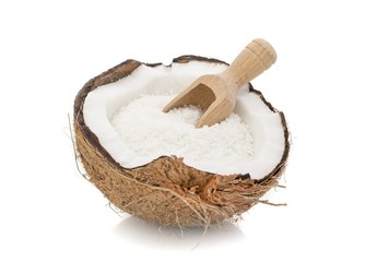 A coconut with desiccated coconut and scoop on white background