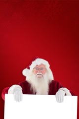 Naklejka premium Composite image of santa is holding a sign