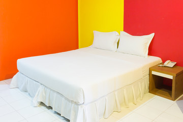 A hotel bedroom with colorful wall