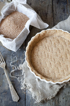 raw wholemeal dough for tart on ceramic mold for quiche