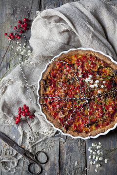 baked red peppers tart on quiche mold on rustic table