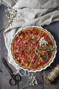 baked red peppers tart on quiche mold on rustic table