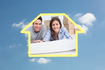 Portrait of a couple lying on the floor and house plan