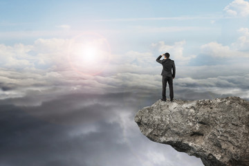 businessman looking on cliff with natural sky daylight cloudscap