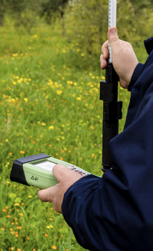 Surveyor with GPS kit at a country roadside