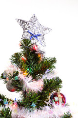 Новогодняя Ёлка (искусственная) на фоне белой стены.