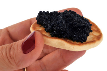 Blinis au caviar en main