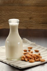 Almond milk in bottle with raw almonds
