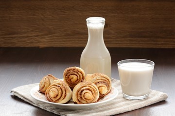 Cinnamon rolls with glass and bottle of milk