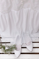 Fototapeta na wymiar Vintage wedding dress and shoes on a wooden background