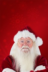Composite image of santa smiles with folded arms