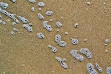 Water foam on the sand background