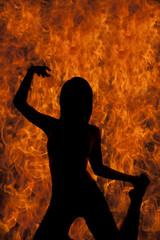 A woman on her knees silhouette in fire