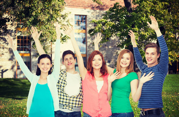 group of smiling students waving hands