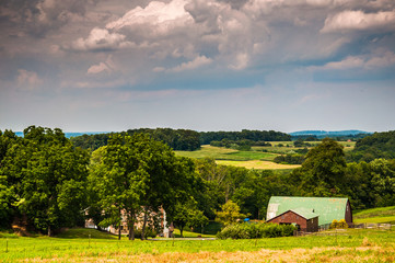 Plakat Stormy sky over a barn and farm fields in rural Southern York Co