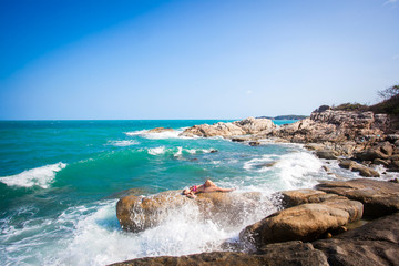 Young sexy woman in red bikini posing In front of sea on the