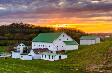 Fototapeta na wymiar Sunset over a barn and farm fields in rural York County, Pennsyl