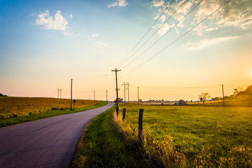 Fototapeta na wymiar Sunset over a country road and farm fields near Hanover, Pennsyl